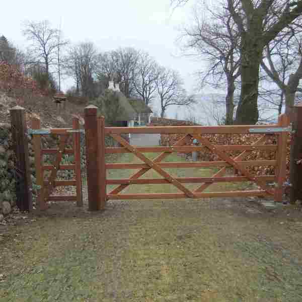 I en indkørsel er der monteret en Country House låge i hårdttræ