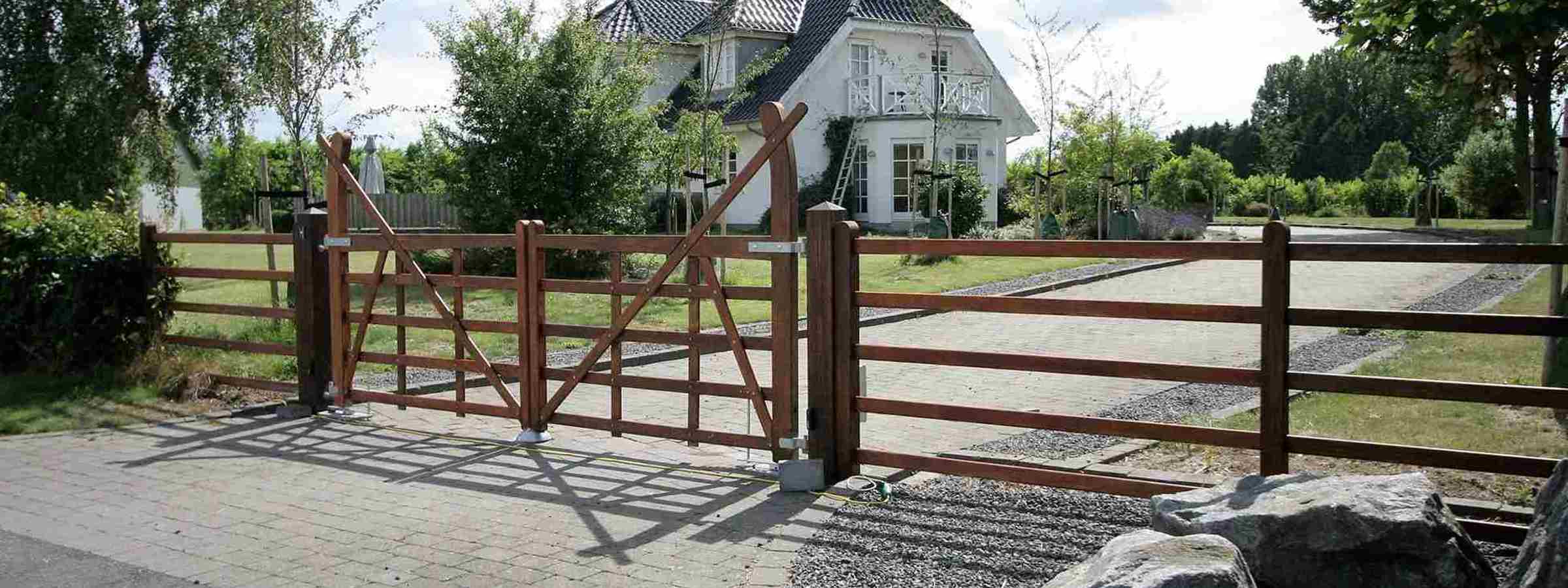 Fra en vej kan man se en indkørsel, som er indhegnet med en Country Ranger låge