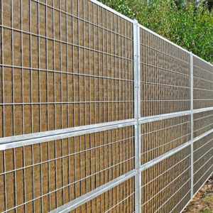 Noistop Essential støjhegn med galvaniseret stålramme og metalpaneler, monteret i et grønt område.