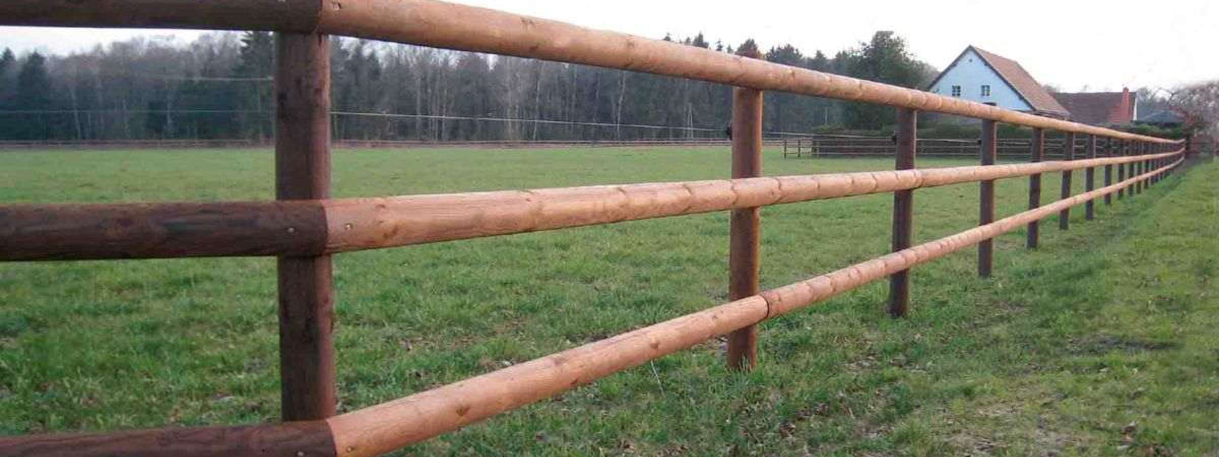 En tom hestefold med et lægtehegn med tre lægter i forgrunden.