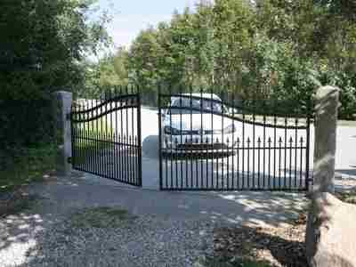 En bil holder bag en smedejernslåge med port automatik som er ved at åbne