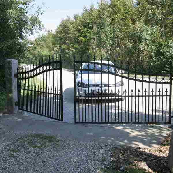 En bil holder bag en smedejernslåge med port automatik som er ved at åbne