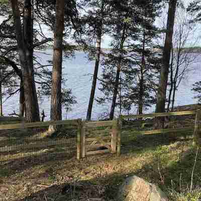 Et hegn bestående af trælægter og nethegn beskytter en kystlinje. Indhegningen er afsluttet med en trælåge