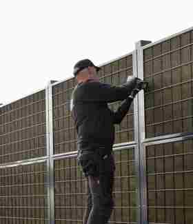 2 hegnsmontører fra Poda Hegn opsætter et Noistop® Steel støjhegn