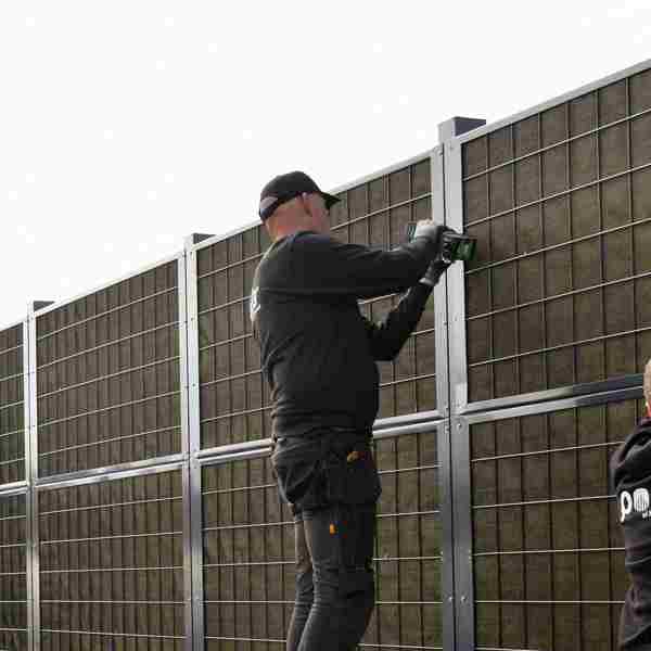2 hegnsmontører fra Poda Hegn opsætter et Noistop® Steel støjhegn