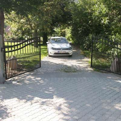 En bil er i færd med at køre gennem en sort smedejernslåge