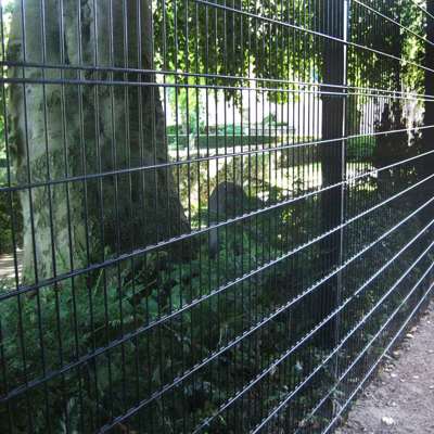 Et sort panelhegn beskytter en kirkegård