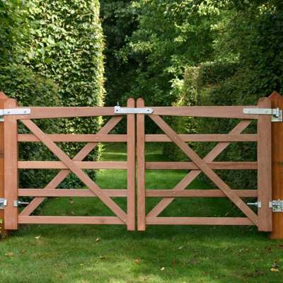 På en sti med grønne buske på hver side, står en Country House låge