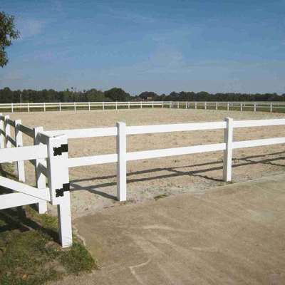 Et hvidt hestehegn i plastik omgrænser en ridebane.