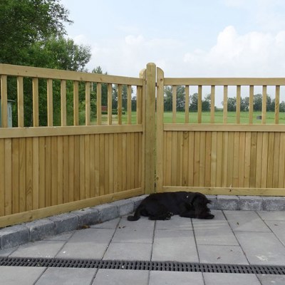 En hund tager en middagslur foran et Country Garden hegn