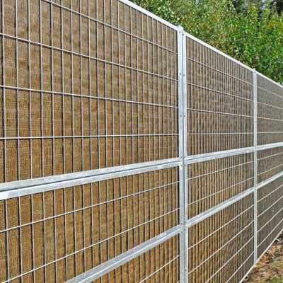 Noistop Essential støjhegn med galvaniseret stålramme og metalpaneler, monteret i et grønt område.