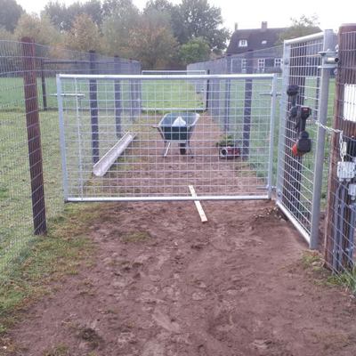 En letvægtslåge med gitter er placeret mellem forskellige indhegninger til alpakaer