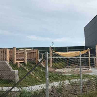 Et Noistop® Steel støjhegn fra Poda Hegn opsat ved en legeplads til en børnehave