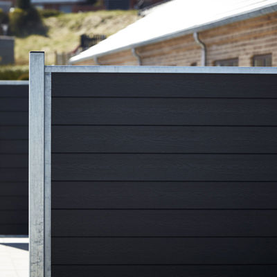 Flere rækker komposithegn på terrasser i boligkvarter.