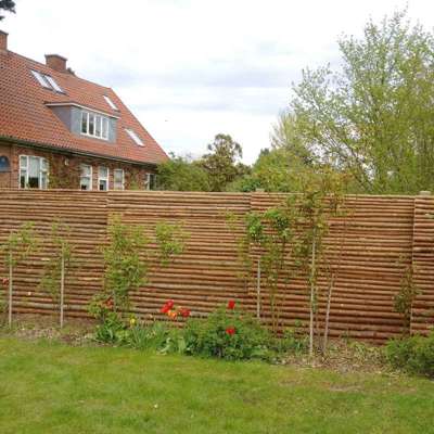 Havehegn lavet i gramrafter med bark bruges som barriere imellem to haver