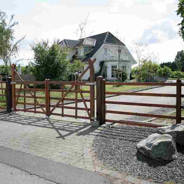 Fra en vej kan man se en indkørsel, som er indhegnet med en Country Ranger låge