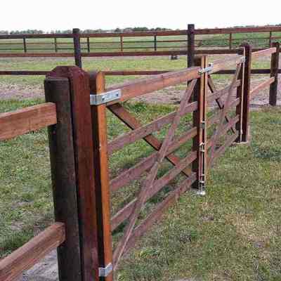 Et hestehegn afgrænser to hestefolde fra hinanden. En dobbelt trælåge giver adgang til den ene hestefold.