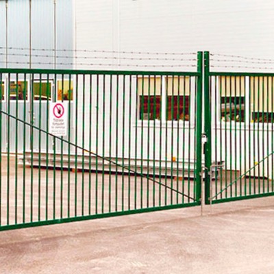 I et industriområde, er der opsat en grøn svingport for at øge sikkerheden hos en virksomhed