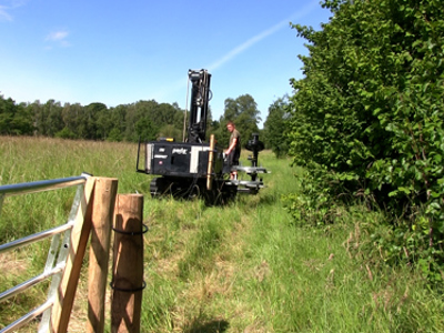 En hegnsmontør er ved at rulle tråd ud til et elektrisk hegn til kvæg.