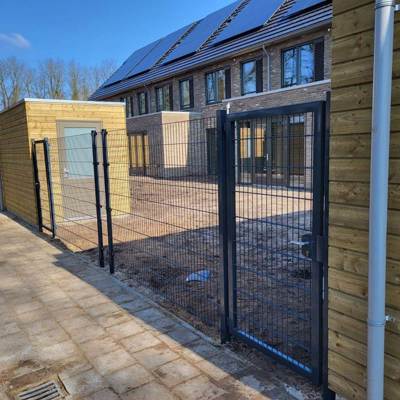 I mellem to skure, er der blevet monteret et panelhegn med en låge