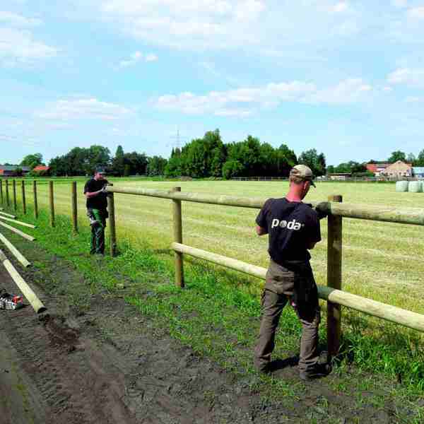 To montører fra Poda er i gang med at montere et klassisk lægtehegn langs en markvej.