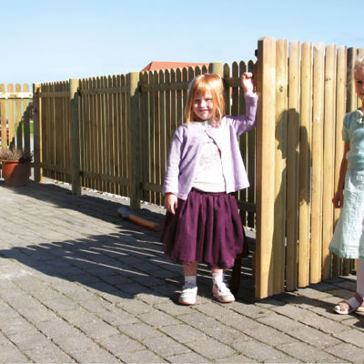 I en indkørsel står to piger op ad et Terndrup stakit
