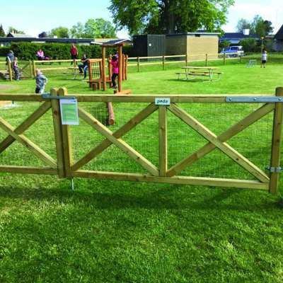 På en legeplads er der opsat en Country Estate låge, som ind- og udgang