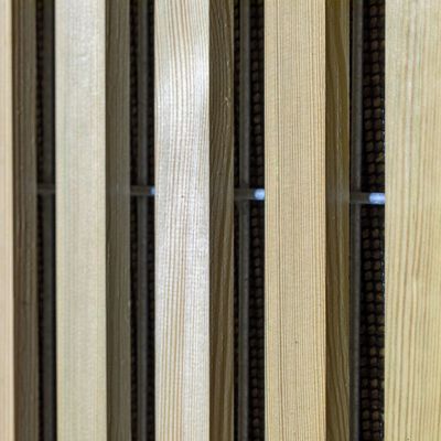 Nærbillede af Noistop Essential støjhegn med lyse trælameller monteret udenpå metalpanelerne.