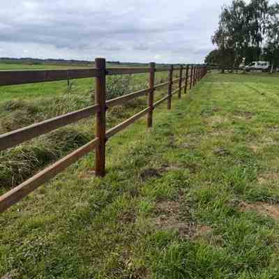Et 3-lægtet lægtehegn adskiller en hestefold fra en mark.