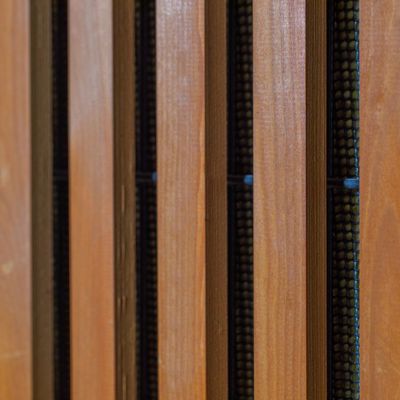 Nærbillede af Noistop Essential støjhegn med tilvalgte trælameller monteret udenpå metalpanelerne.